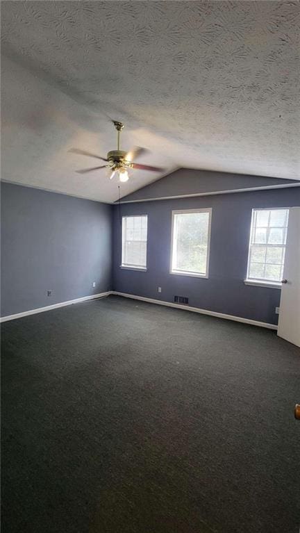 carpeted spare room with lofted ceiling, ceiling fan, plenty of natural light, and a textured ceiling