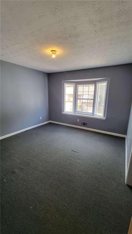 carpeted spare room with a textured ceiling