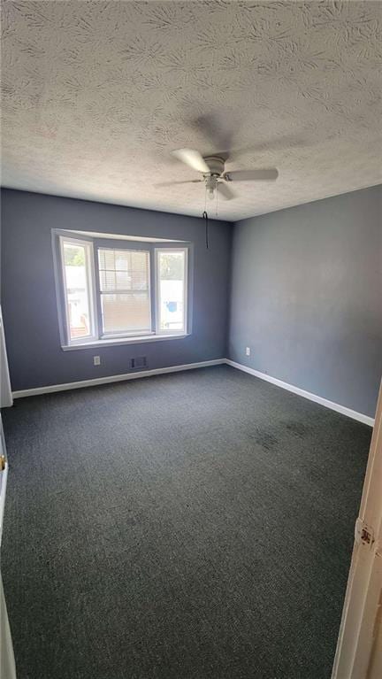 unfurnished room with a textured ceiling, dark colored carpet, and ceiling fan