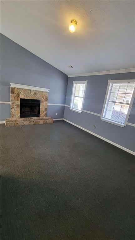 unfurnished living room featuring dark carpet, vaulted ceiling, and a stone fireplace