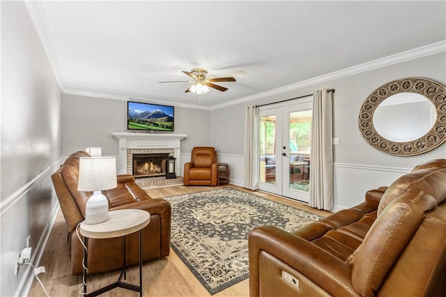 135 Crimson Rdg, Tyrone, GA 30290 - living room with light wood finished floors, ornamental molding, a ceiling fan, french doors, and a brick fireplace