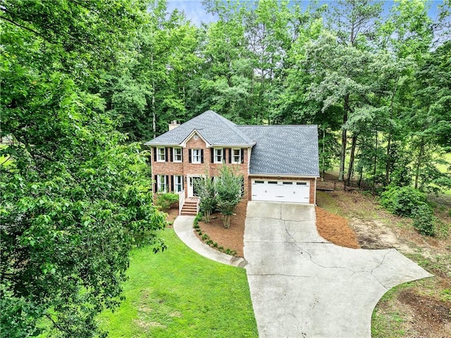 135 Crimson Rdg, Tyrone, GA 30290 - colonial home featuring concrete driveway, brick siding, a chimney, a front lawn, and a garage