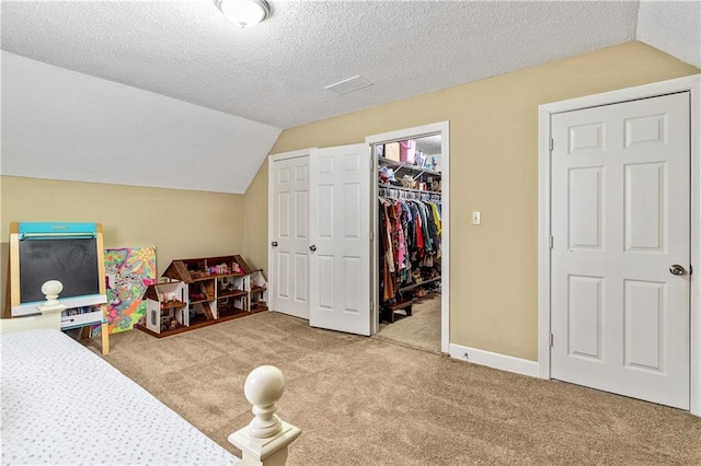 135 Crimson Rdg, Tyrone, GA 30290 - bedroom featuring carpet flooring, vaulted ceiling, a walk in closet, a closet, and a textured ceiling