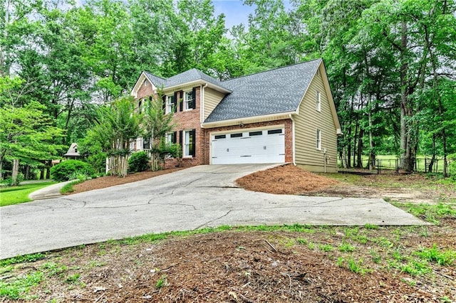 135 Crimson Rdg, Tyrone, GA 30290 - colonial home featuring concrete driveway, an attached garage, view of wooded area, brick siding, and a shingled roof