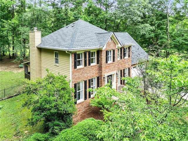 135 Crimson Rdg, Tyrone, GA 30290 - view of front of property with a chimney, brick siding, roof with shingles, and view of scattered trees