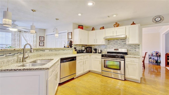 kitchen featuring pendant lighting, sink, appliances with stainless steel finishes, white cabinets, and kitchen peninsula