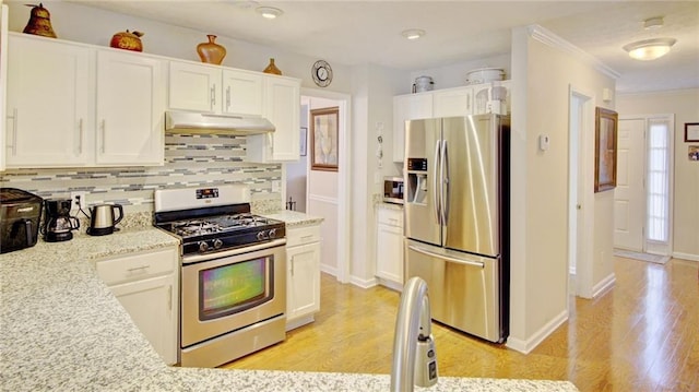 kitchen featuring appliances with stainless steel finishes, light stone counters, ornamental molding, white cabinets, and decorative backsplash