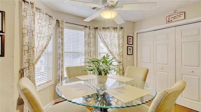 dining space featuring hardwood / wood-style flooring, ceiling fan, a textured ceiling, and a wealth of natural light