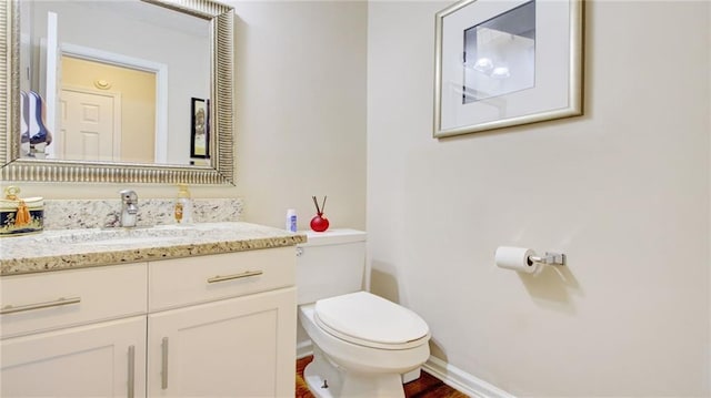 bathroom with vanity, toilet, and wood-type flooring