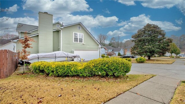 view of home's exterior with a garage and a lawn