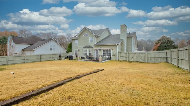 back of house with a yard and a patio