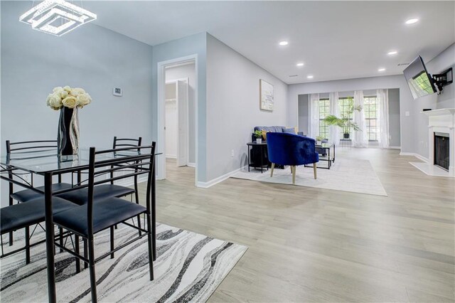 dining area featuring a premium fireplace and light wood-type flooring