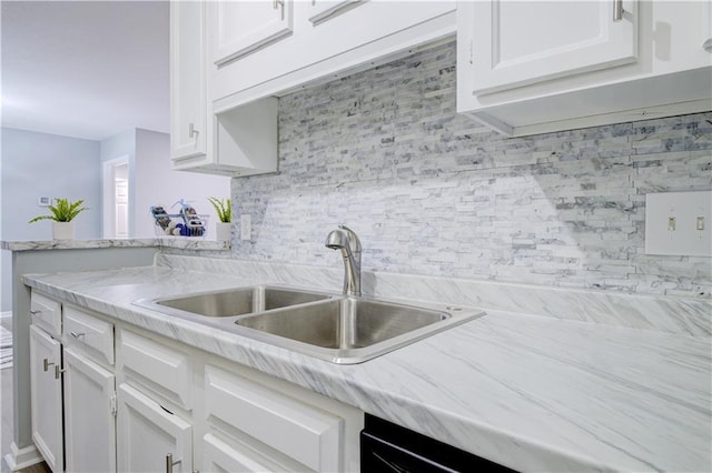 kitchen featuring white cabinetry, light stone countertops, sink, and tasteful backsplash