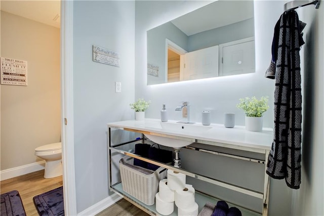 bathroom featuring sink, wood-type flooring, and toilet