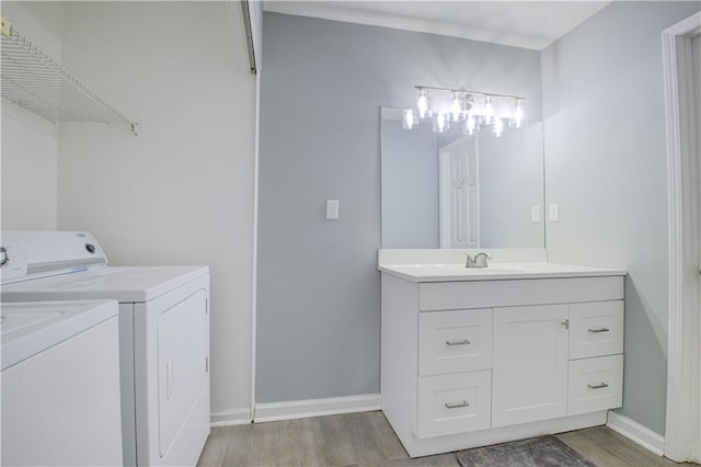 bathroom with vanity, separate washer and dryer, and hardwood / wood-style floors