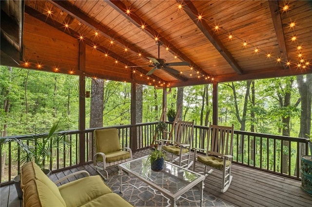 sunroom with beamed ceiling, an outdoor living space, and a ceiling fan