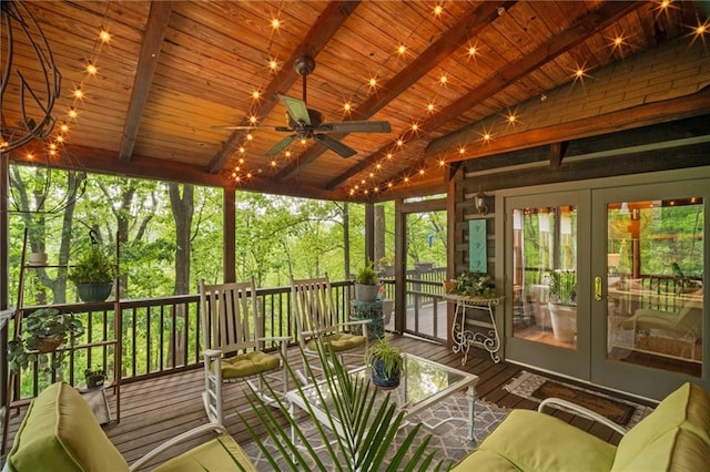 sunroom / solarium featuring beamed ceiling and french doors
