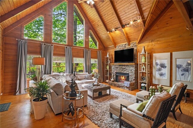 living room with wooden walls, wood ceiling, and a wealth of natural light