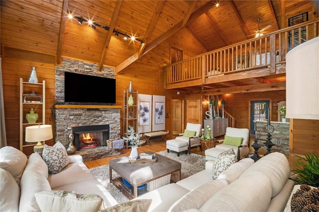 living area with high vaulted ceiling, wood walls, wood ceiling, and wood finished floors