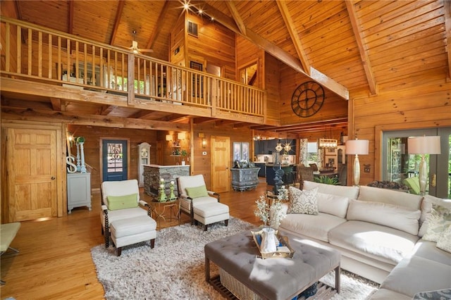 living area featuring wood walls, a wealth of natural light, and high vaulted ceiling