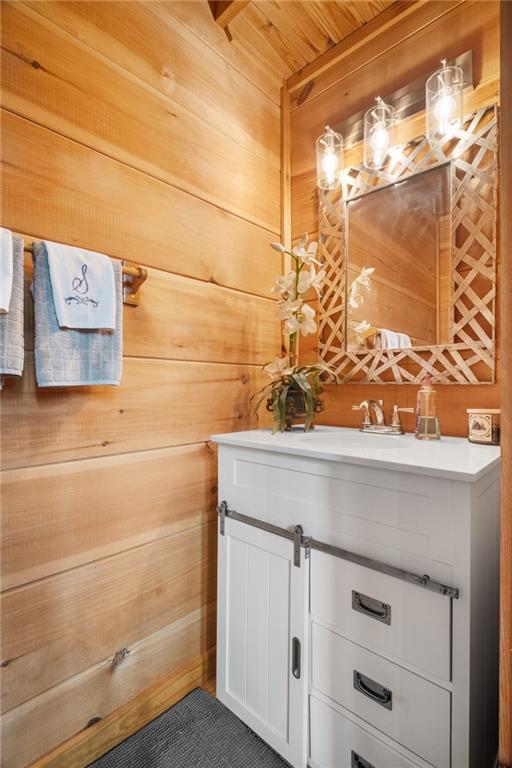 bathroom with wooden walls and vanity