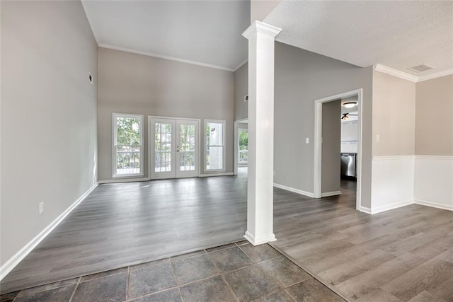 unfurnished living room with a high ceiling, dark hardwood / wood-style floors, ornate columns, and ceiling fan