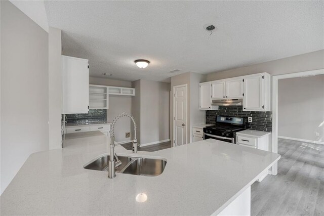 kitchen with stainless steel gas stove, sink, backsplash, light hardwood / wood-style floors, and white cabinets