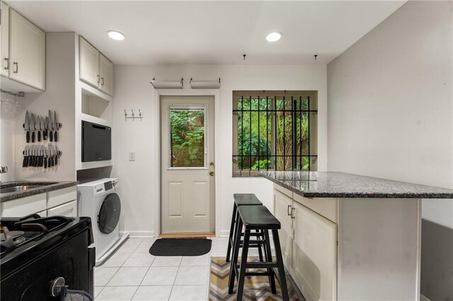 148 Waverly Way Unit 10, Atlanta, GA 30307 - kitchen with a sink, washer / dryer, black appliances, and white cabinetry