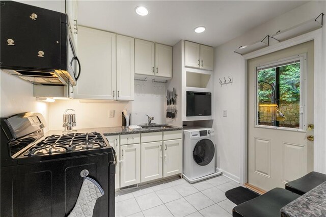 148 Waverly Way Unit 10, Atlanta, GA 30307 - kitchen featuring washer / clothes dryer, white cabinetry, a sink, light tile patterned floors, and black appliances