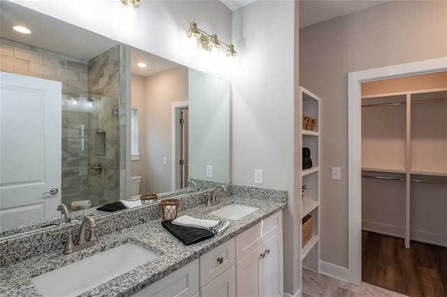 bathroom featuring vanity, toilet, and a shower with door