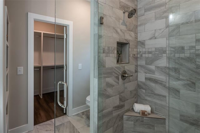 bathroom with toilet and a shower with shower door