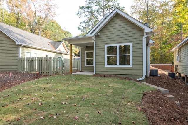 rear view of house with a yard and central AC