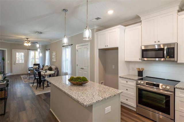 kitchen featuring appliances with stainless steel finishes, ceiling fan, decorative light fixtures, white cabinets, and a center island