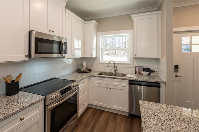 kitchen with appliances with stainless steel finishes, light stone counters, dark wood-type flooring, sink, and white cabinets