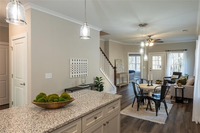 dining space featuring dark hardwood / wood-style floors, ceiling fan, and crown molding