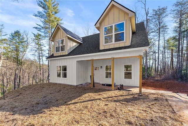 modern farmhouse featuring board and batten siding and roof with shingles