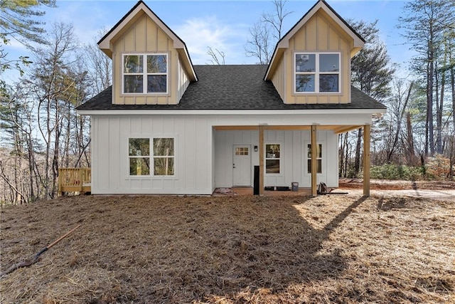 rear view of house featuring board and batten siding and a shingled roof