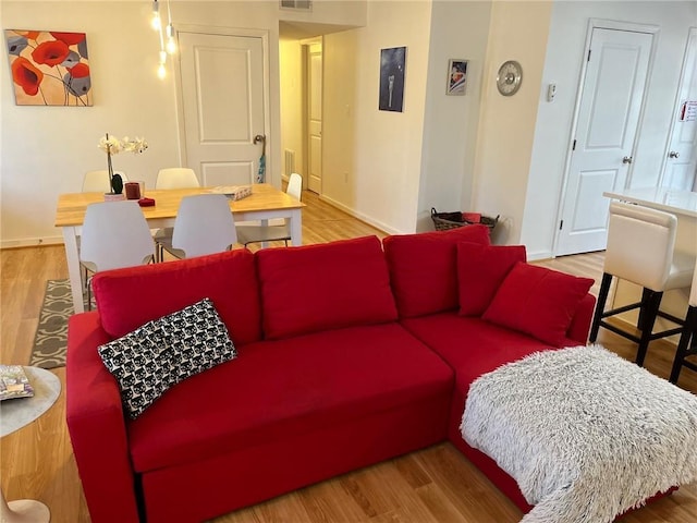 living area with baseboards and wood finished floors