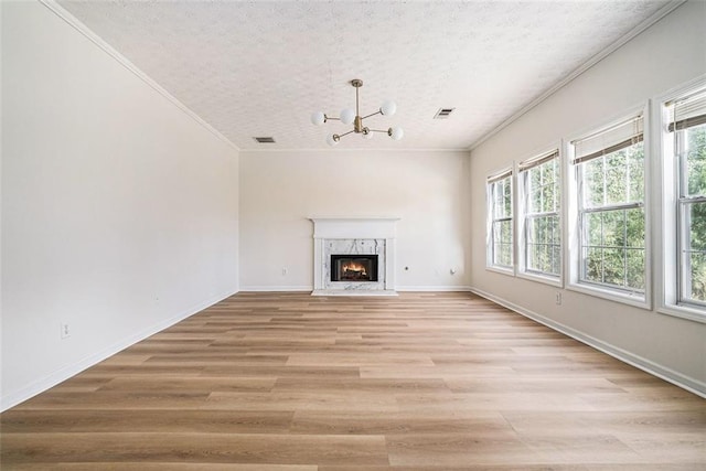 unfurnished living room featuring light wood-style flooring, plenty of natural light, and ornamental molding