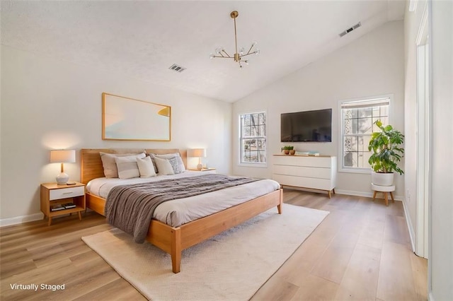 bedroom with light wood-type flooring, visible vents, baseboards, and vaulted ceiling