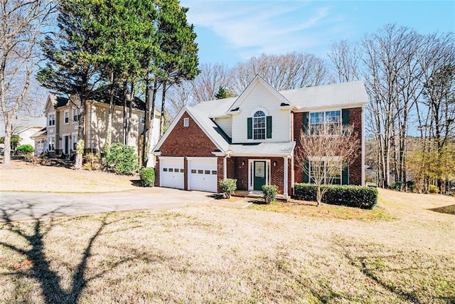 traditional-style house featuring a front lawn, an attached garage, brick siding, and driveway