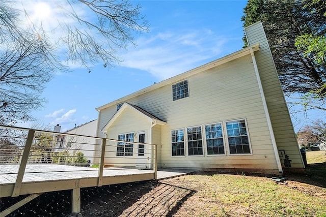 rear view of house featuring a deck and a chimney