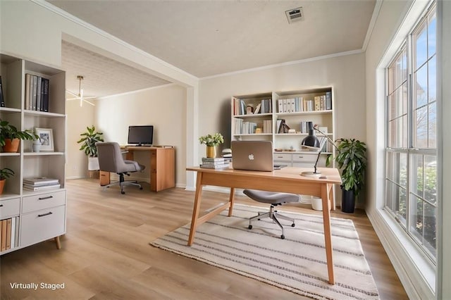 office space featuring a wealth of natural light, light wood-style flooring, and crown molding