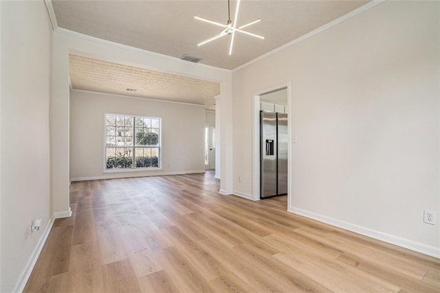 spare room with visible vents, baseboards, crown molding, and light wood finished floors