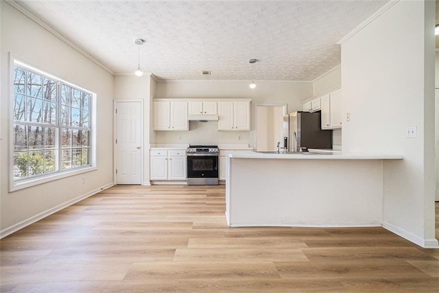 kitchen featuring a peninsula, stainless steel appliances, light wood-style floors, a textured ceiling, and white cabinetry