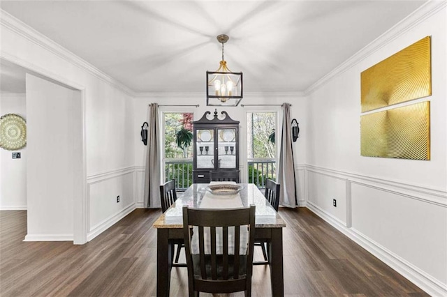 dining room featuring a notable chandelier, ornamental molding, and dark wood-style flooring