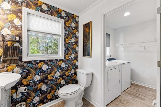 bathroom with washer and dryer, baseboards, wood finished floors, and wallpapered walls