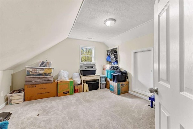 interior space with vaulted ceiling, carpet, baseboards, and a textured ceiling