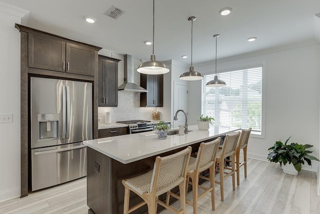 1117 Larkin Dr, Buford, GA 30518 - kitchen featuring appliances with stainless steel finishes, wall chimney range hood, baseboards, tasteful backsplash, and a breakfast bar