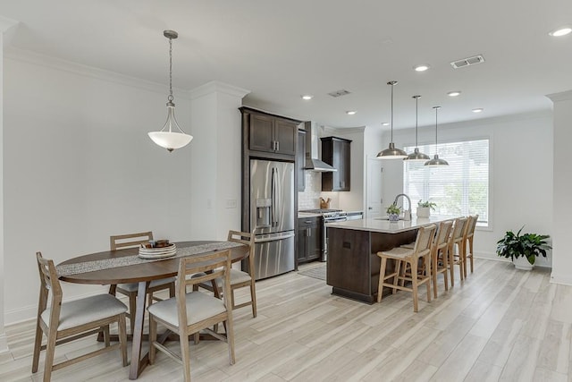 1117 Larkin Dr, Buford, GA 30518 - kitchen with appliances with stainless steel finishes, wall chimney exhaust hood, a sink, ornamental molding, and light countertops
